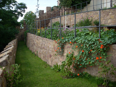 Blick hinter Mauern ins kleine Gärtlein